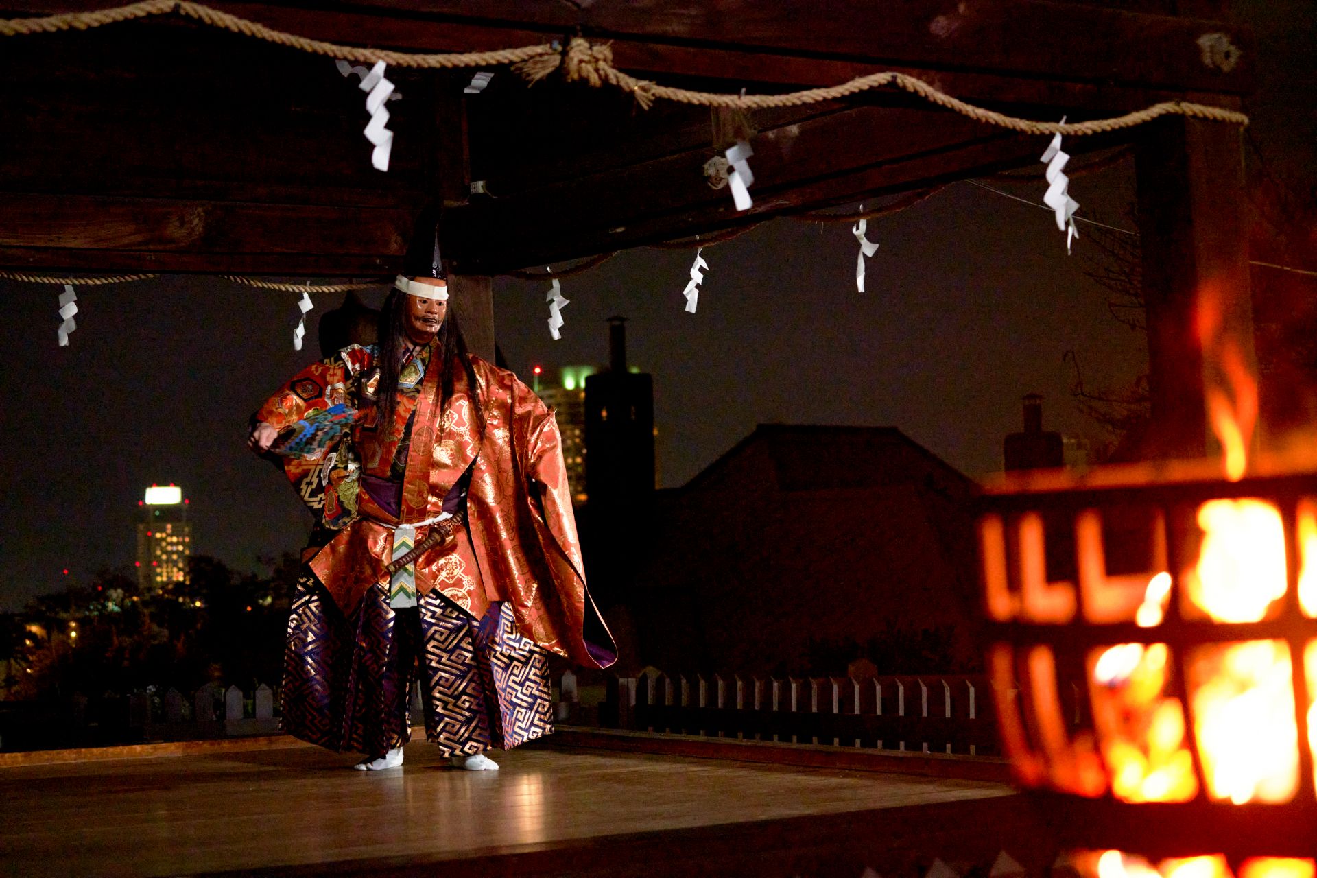 在以神戶夜景為背景的篝火照亮的能舞台上表演的箭袋舞。精緻之美