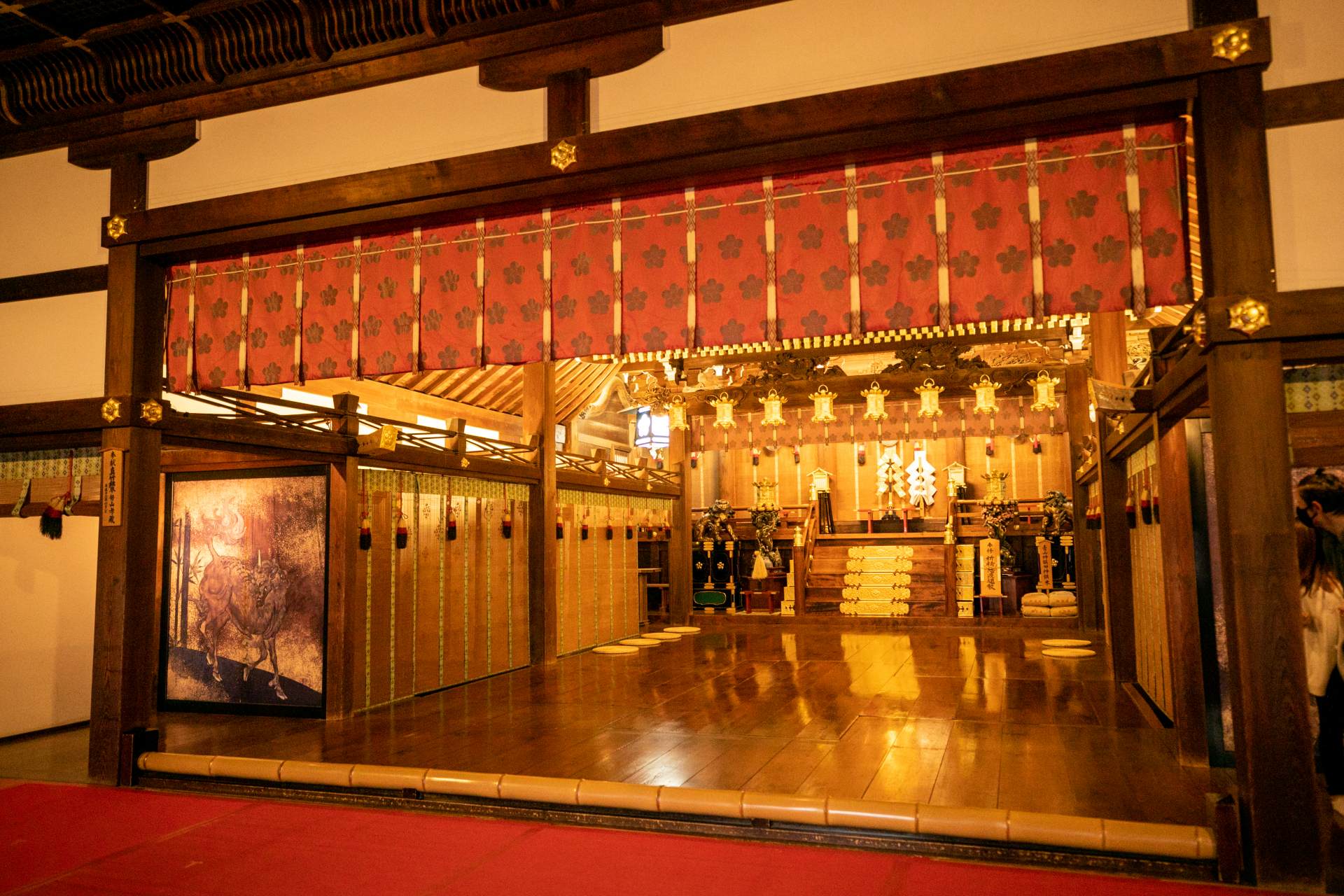 Inside the main hall with its majestic and sacred atmosphere. From the low bamboo partition to the altar in the back is the Haiden (hall of offerings).