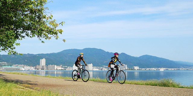 Andar en bicicleta mientras disfruta del hermoso paisaje del lago Biwa, que fue seleccionado como la primera ruta ciclista nacional