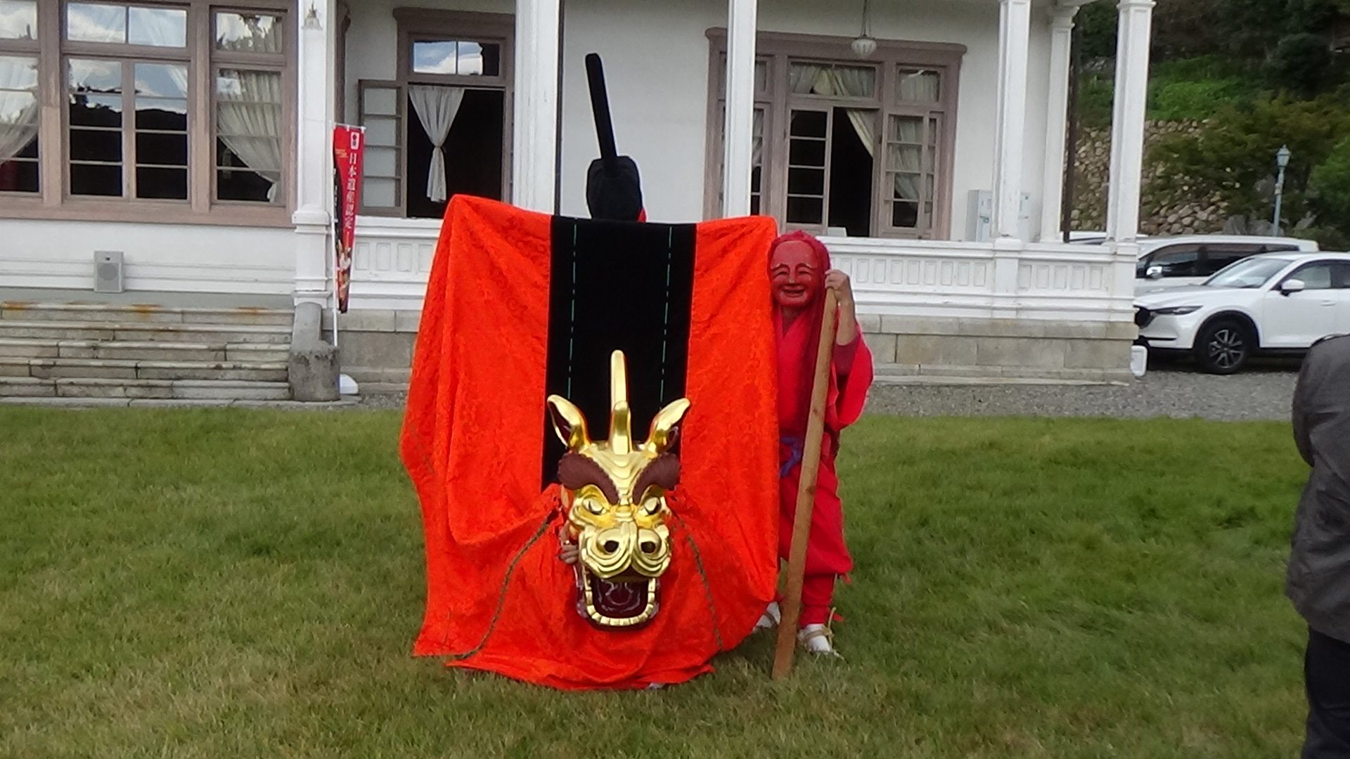 Deux adultes dans le domaku dansent en harmonie. Celui qui ouvre la voie est un renard avec un bâton rouge.