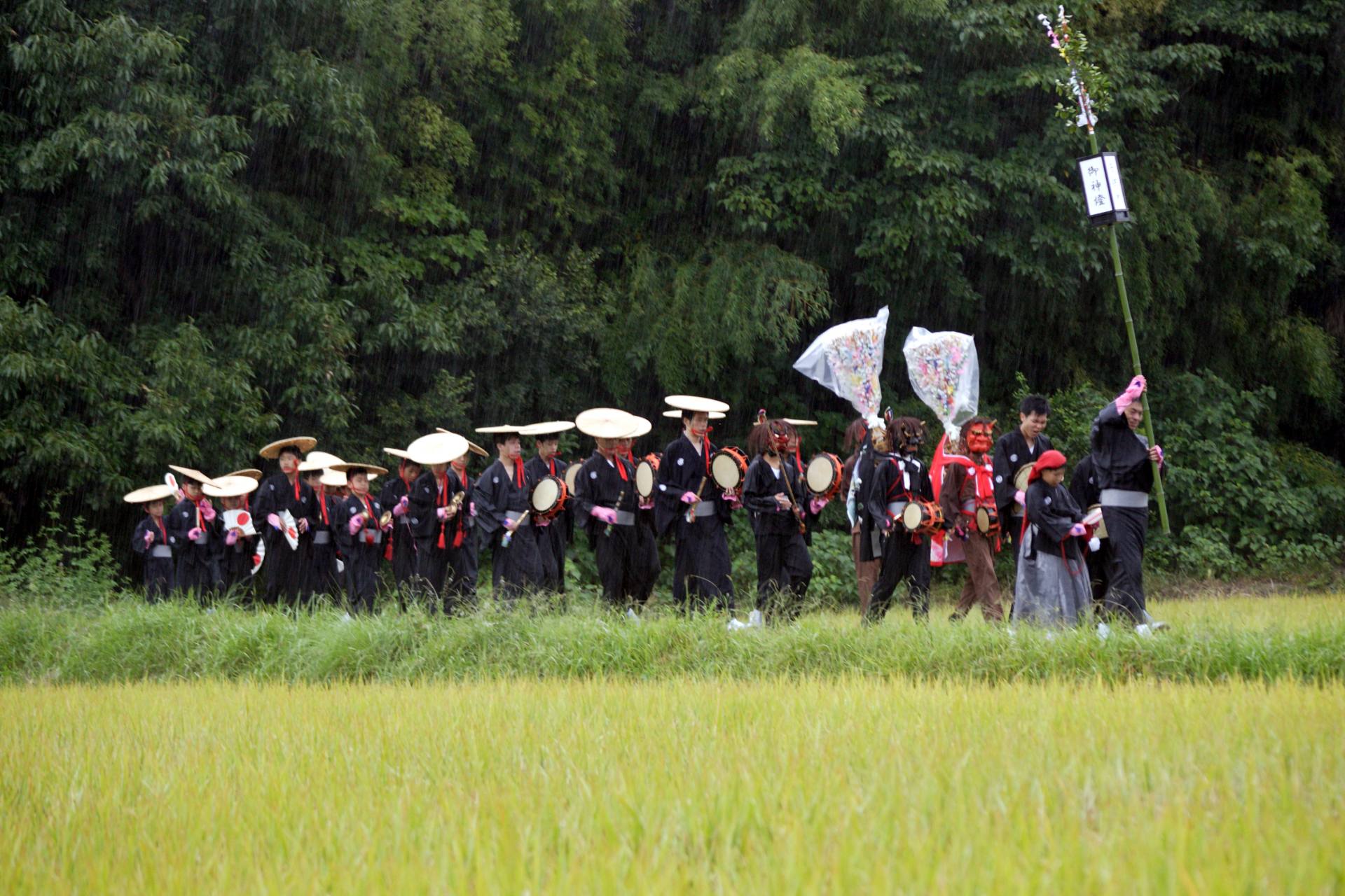 道歌をうたいながら村を練り歩く一行。集落の人びとは、一行の歌声で祭りの訪れを知る。