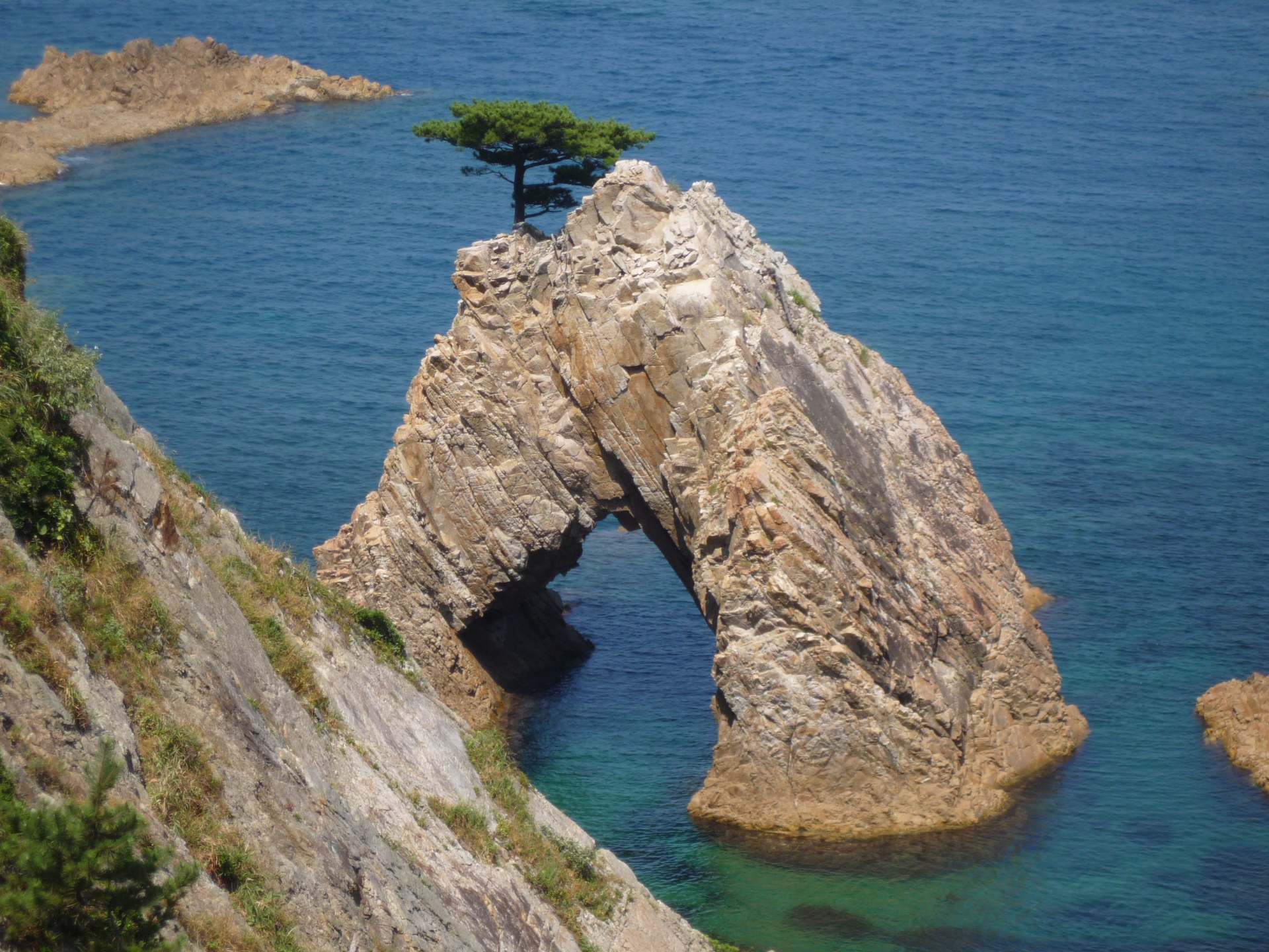 50m (164 ft) in circumference and 10m (33 ft)-tall cave is topped with a pretty pine tree. Sengan Matsushima is one of the incredible rocks of the Uradome Coast.