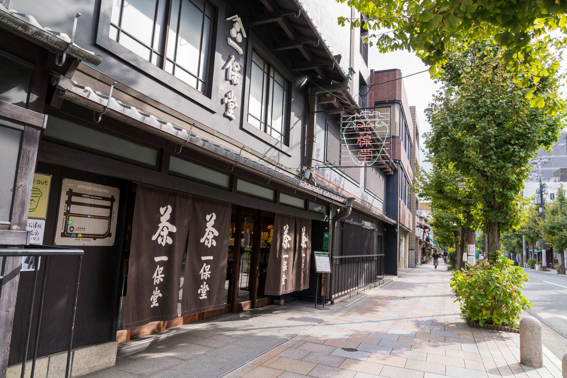 一保堂茶保京都總店，染成棕色和白色的門簾在堅固的黑牆建築中顯得格外醒目