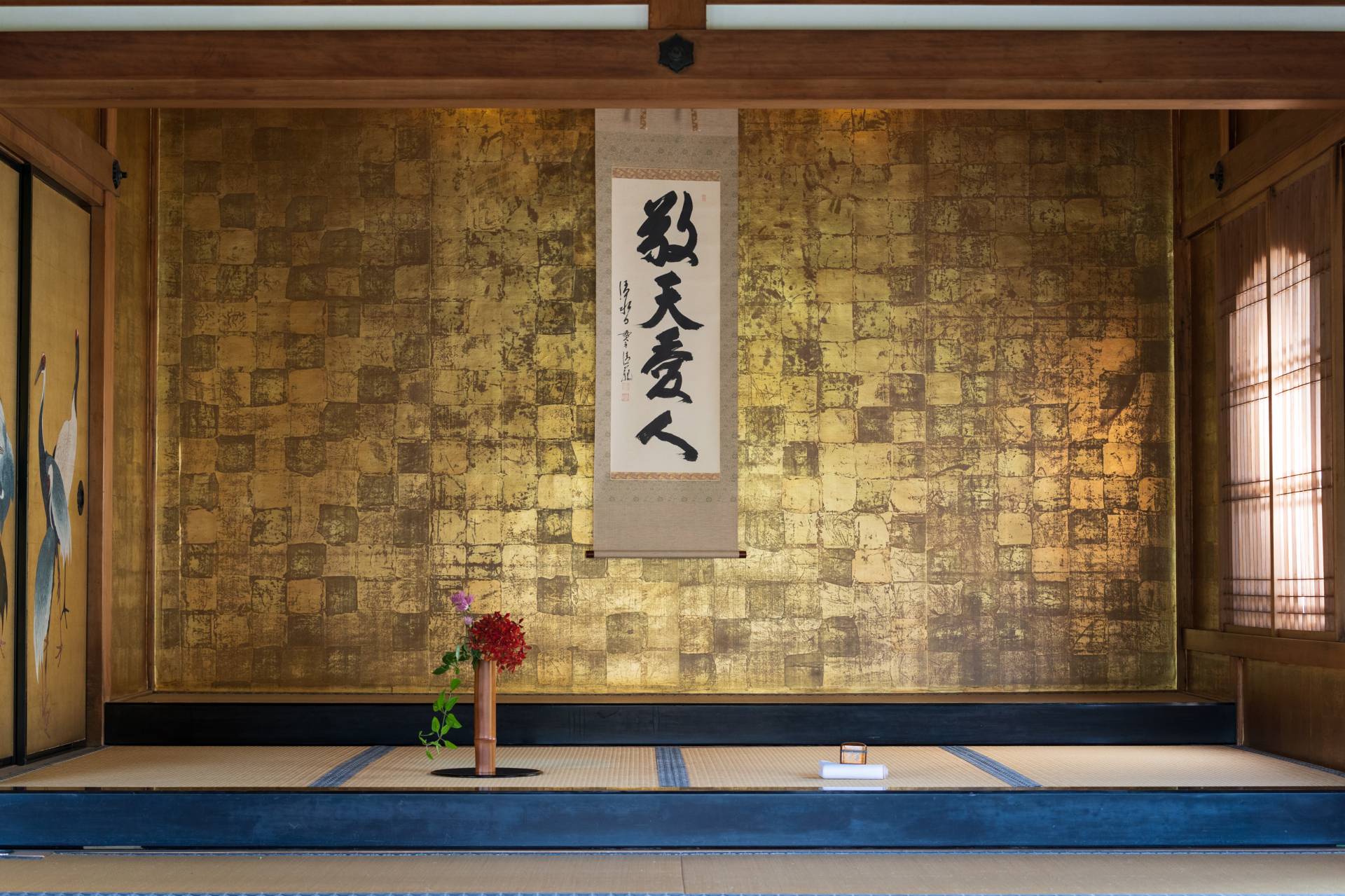 The room was prepared by the iemoto with a hanging scroll and flowers he had arranged.