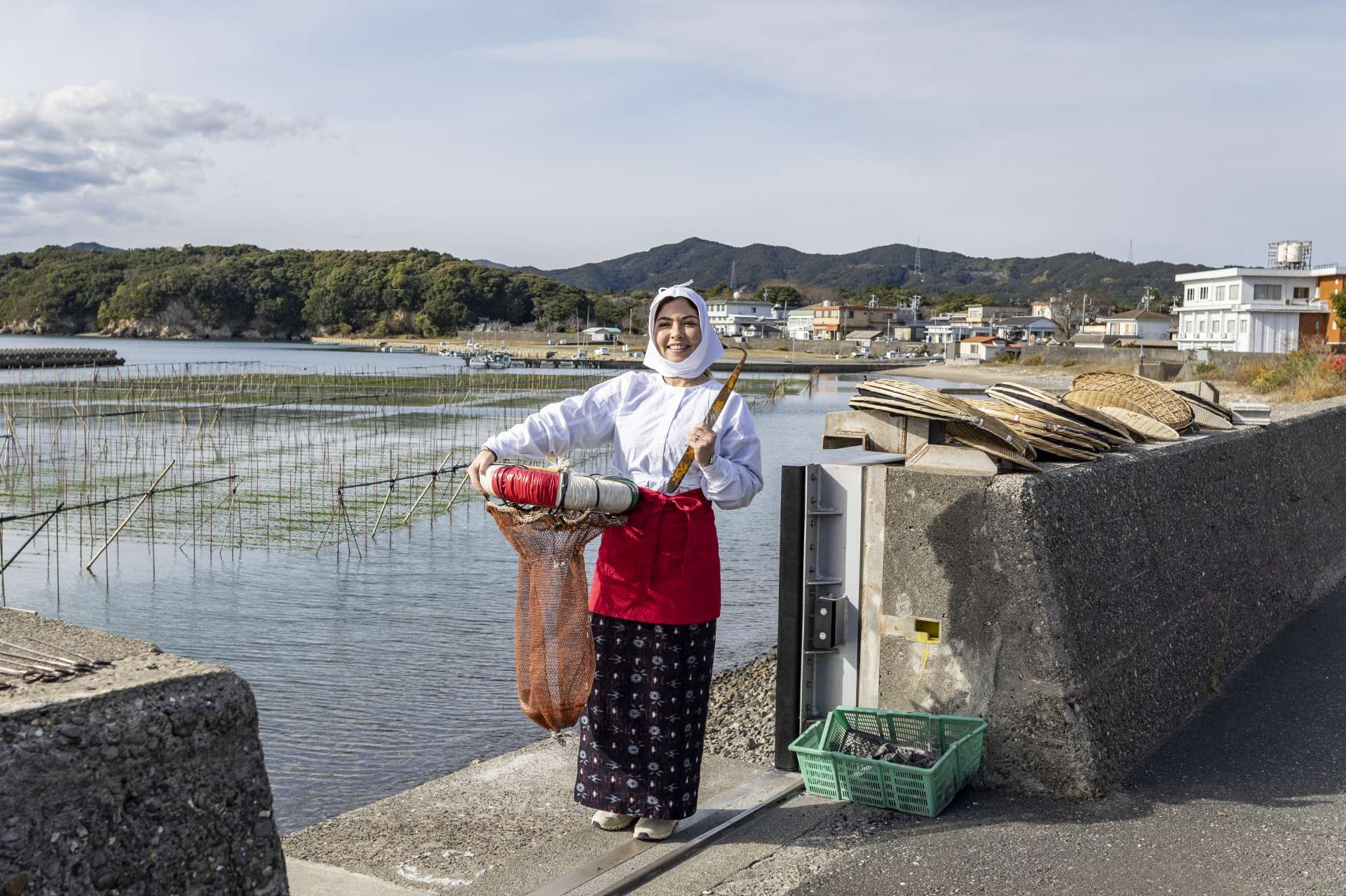 伝統的な海女の服、磯着の着付け体験をして水中がどんなに冷たかったかを想像する。