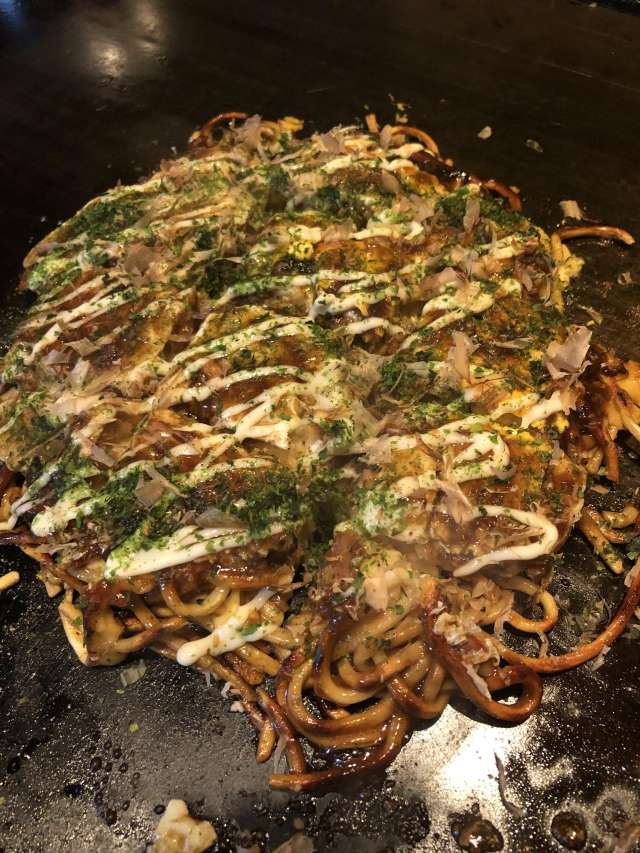 A hearty Modern-yaki Okonomiyaki with one portion of soba noodle seasoned with dashi and sauce
