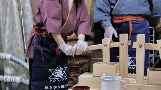 Visitors can experience soy sauce pressing while dressed in authentic brewery clothing.