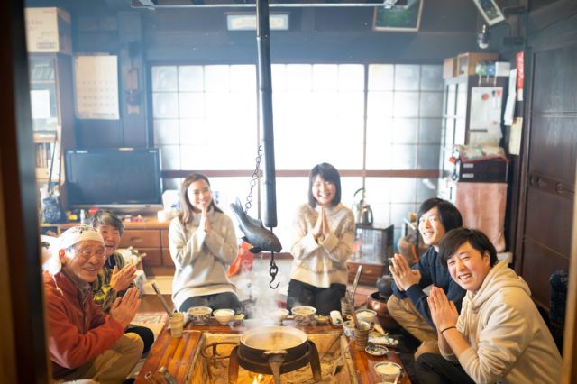 Participants and a farmer around the fireplace
（C）一般社団法人南丹市美山観光まちづくり協会