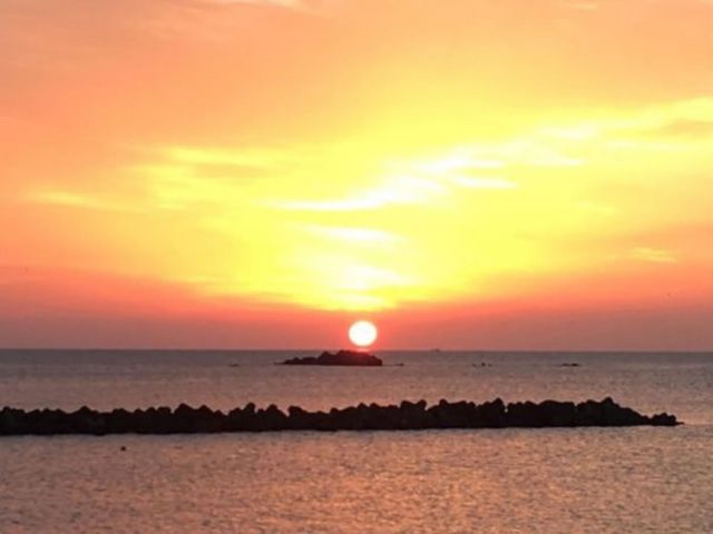 The morning sun rising over the horizon as seen from a sea-facing guest room.