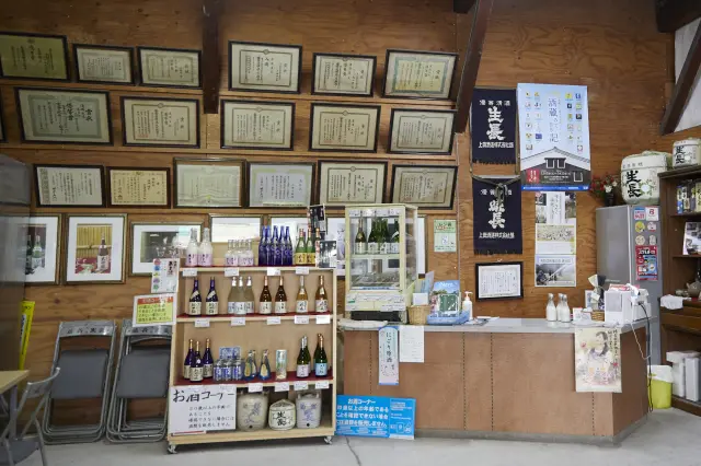 様々な商品が並ぶ直売所と壁に並ぶ数々の表彰状