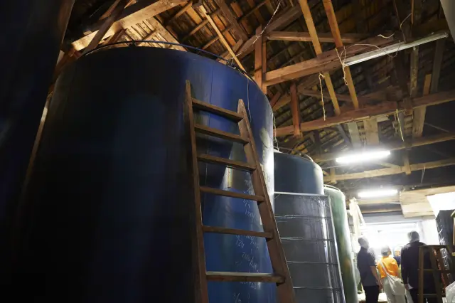 The factory's interior, dating back to 1945, features a row of traditional fermentation tanks.