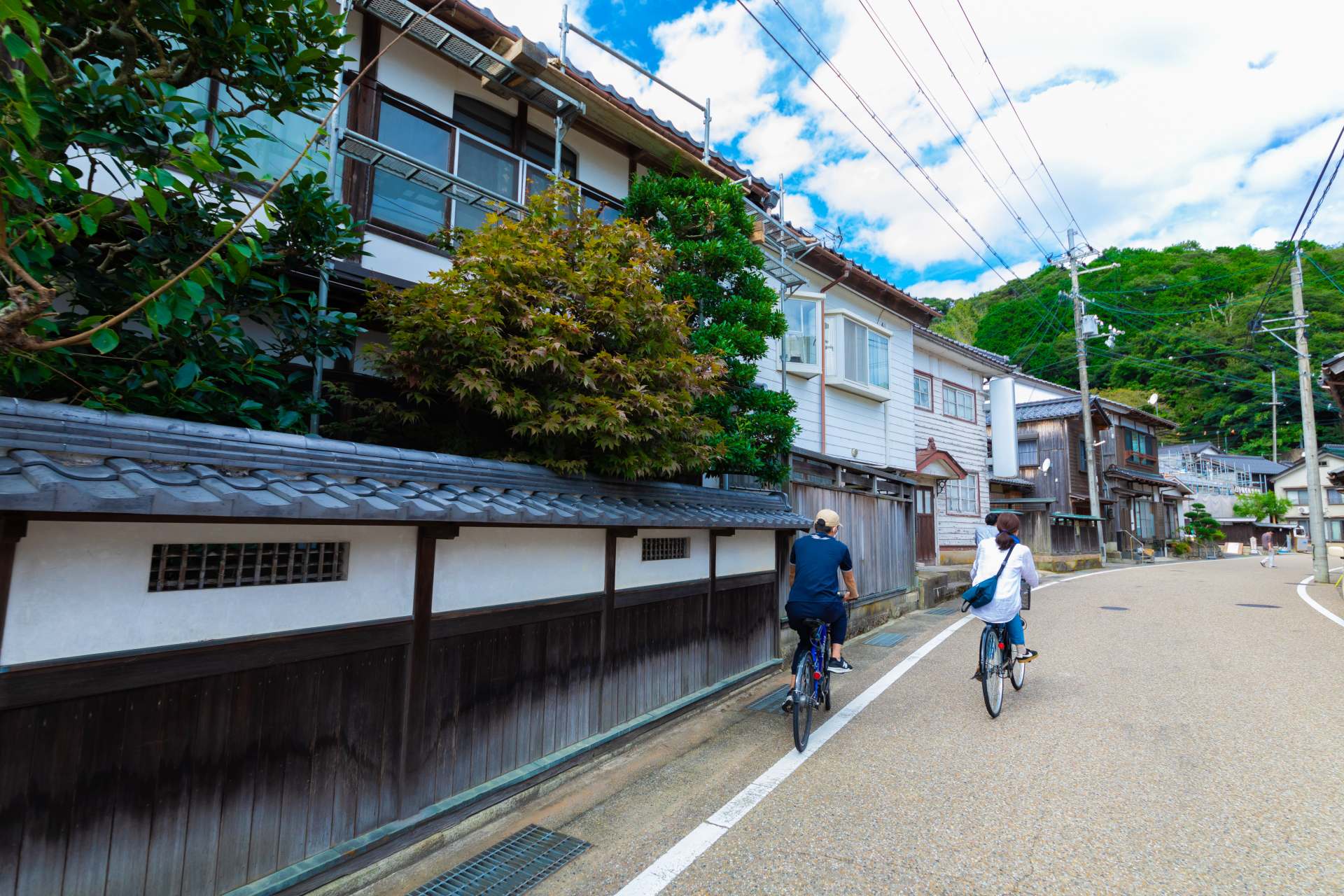 伊根の町並みをサイクリング。地酒の造り酒屋や舟屋のカフェもあります。